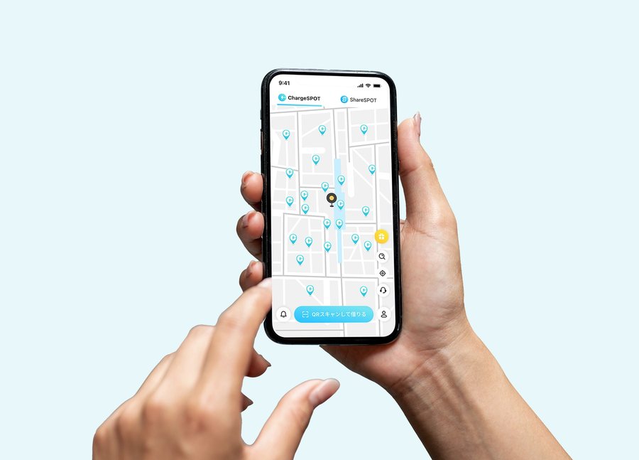 Màn hình bản đồ của ứng dụng CHARGESPOT. Các trụ pin xung quanh hiển thị bằng ghim, phía dưới màn hình có nút "QRスキャンして借りる" (quét QR để thuê)